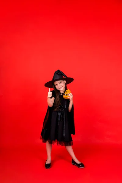 Happy Full Length Girl Witch Costume Holds Pumpkin Red Background — 스톡 사진