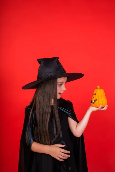 Cute Girl Witch Costume Holds Pumpkin Red Background Copy Space — 스톡 사진