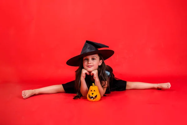 Little Girl Witch Costume Hat Sitting String Pumpkin Red Background — 스톡 사진