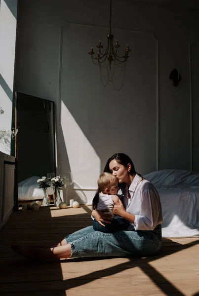 Happy Brunette Mom Baby Girl Kissing Wooden Floor Rays Light — 스톡 사진