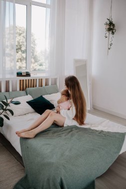 Anne ve küçük kızı odada yatakta birbirlerine sarılıyorlar.