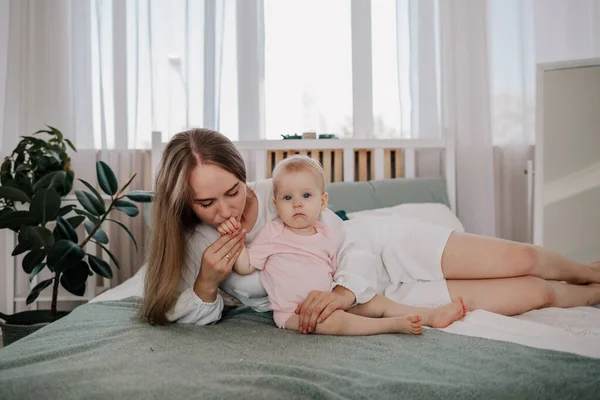 Mama Liegt Mit Einem Kleinen Mädchen Musselinjumpsuit Auf Dem Bett — Stockfoto