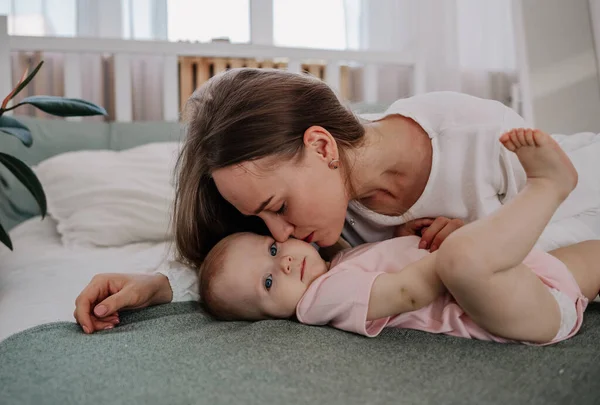 Mama Leży Łóżku Dziewczynką Łóżku Pokoju Całuje — Zdjęcie stockowe