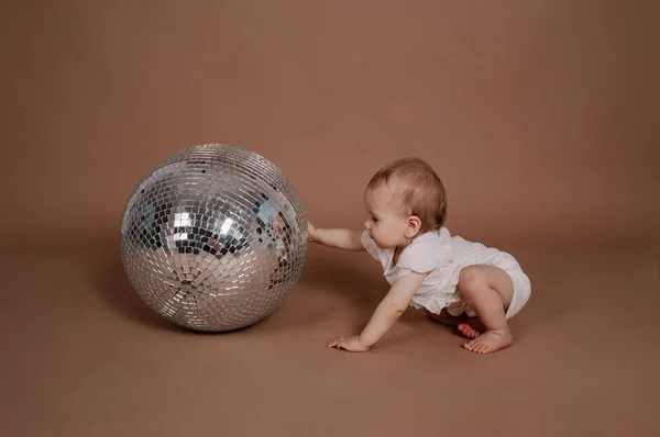 Una Bambina Tuta Bianca Gioca Con Una Palla Discoteca Argentata — Foto Stock