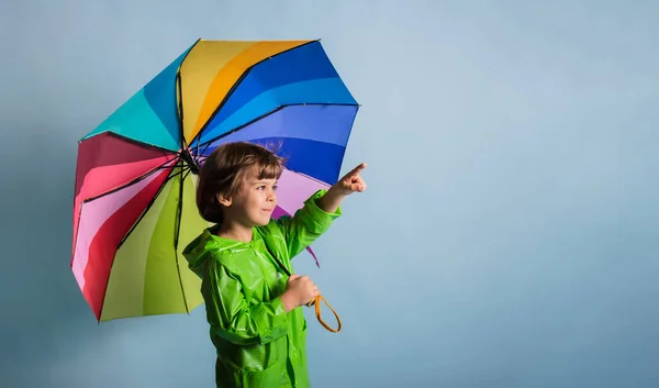 Niño Pequeño Con Impermeable Verde Sostiene Paraguas Multicolor Señala Hacia — Foto de Stock