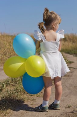 the girl in the field with balloons