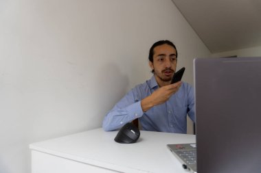 İş adamı sesli mesaj gönderiyor. Adam akıllı telefonunda ses tanıma sistemi kullanıyor. ev ofisi