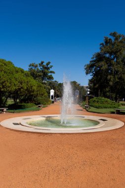 Kırmızı toprakla çevrili yuvarlak su çeşmesi, Rosedal 'daki bir peyzaj tasarımcısının işi. Buenos Aires Arjantin. Dünyanın en güzel bahçesine. Dünyanın en güzel parkı. Doğanın mucizesi.