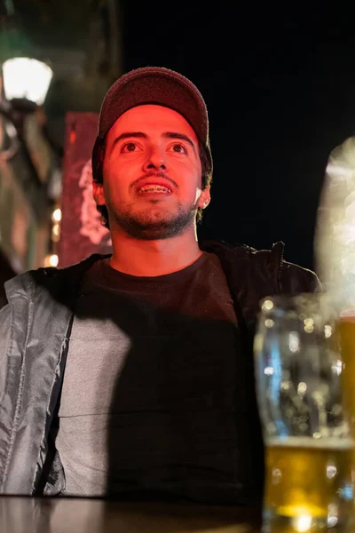 Homem Latino Sorrindo Enquanto Bebe Algumas Cervejas Sob Uma Luz — Fotografia de Stock