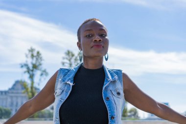 Siyah, Afro-Amerikalı, kendine güvenen bir yüzü olan kadın doğrudan kameraya bakıyor. Haitili kadın