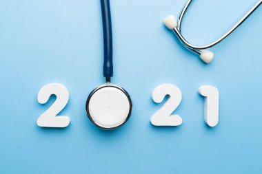 Mavi arka planda 2021 numaralı steteskop. Sağlık hizmetleri ve sağlık afişi ve takvim kapağı için mutlu yıllar. Tıp tedavi ve tanı konseptinde yeni bir eğilim için yaratıcı fikir.