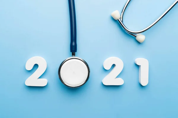 Mavi arka planda 2021 numaralı steteskop. Sağlık hizmetleri ve sağlık afişi ve takvim kapağı için mutlu yıllar. Tıp tedavi ve tanı konseptinde yeni bir eğilim için yaratıcı fikir.