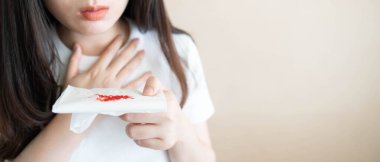 Woman have a coughing up blood and chest pain. Close up of hands holding tissue paper with bloody sputum. Cause of hemoptysis include TB, lung cancer, bronchitis, pneumonia or pulmonary embolism. clipart