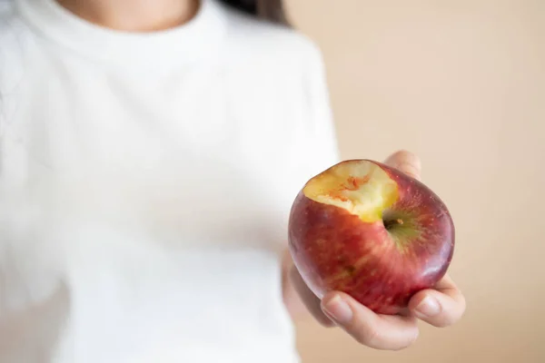 Woman have bleeding gums after biting an apple. Bleeding gums are a sign of gingivitis, periodontitis or vitamin deficiency. Dental health care concept.