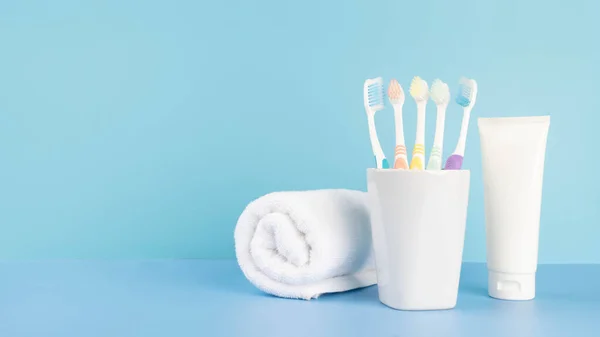 Toothbrushes Glass Toothpaste Towel Light Blue Table Bathroom Dental Health — Stock Photo, Image