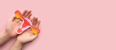 Kadın üreme sağlığı konsepti. Rahim şeklindeki kadın, pembe arka plan kağıdından yapılmış. Endometriyozis, PCOS, STD veya jinekolojik kanser gibi rahim hastalıklarına karşı farkındalık.