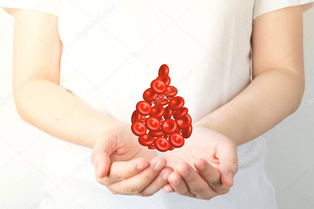 Blood donation. Human hands holding blood drop shape of red blood cells over white background. World blood donor day and save life concept.