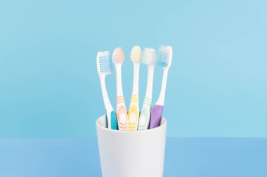 Gözlüklü Asyalı kadın, mavi arka plandaki işten sonra yorgun gözlerini ovuşturuyor. Göz yorgunluğu belirtileri sulu gözler, kuru gözler, bulanık görme ve kaşınan gözler.