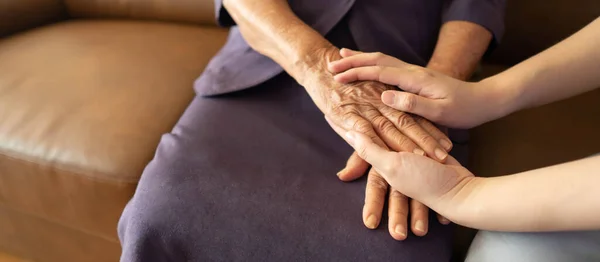 介護者と高齢者の女性が手を握っている 介護家族介護者の支援 シニアサービスと高齢者介護の概念 — ストック写真