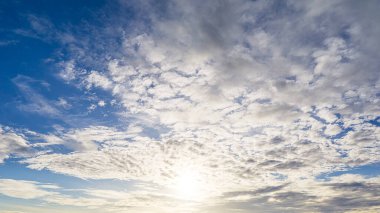 Mavi gökyüzünde gün doğumu ve pofuduk beyaz bulutlu arkaplan görüntüsü