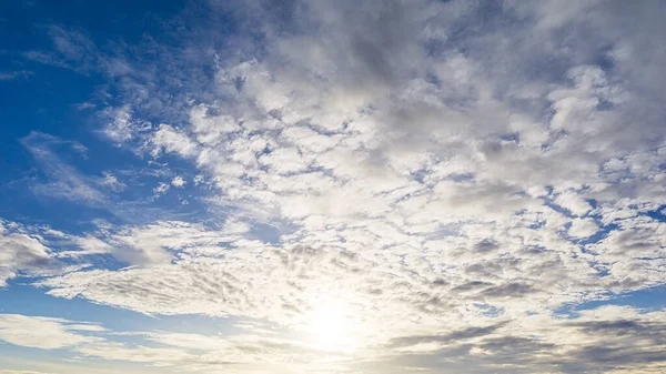Mavi gökyüzünde gün doğumu ve pofuduk beyaz bulutlu arkaplan görüntüsü