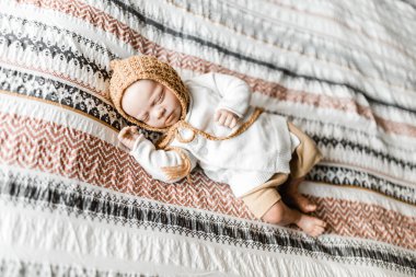 Yeniden doğan bebek yatağında, üzerinde bir başlık olan dovet örtüsüyle yatıyor. Bebek gibi görünmesine gerek yok.