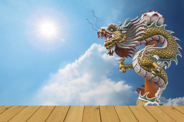 Dragon, mavi gökyüzü arka plan üzerinde ahşap zemin ile güneş patlaması 