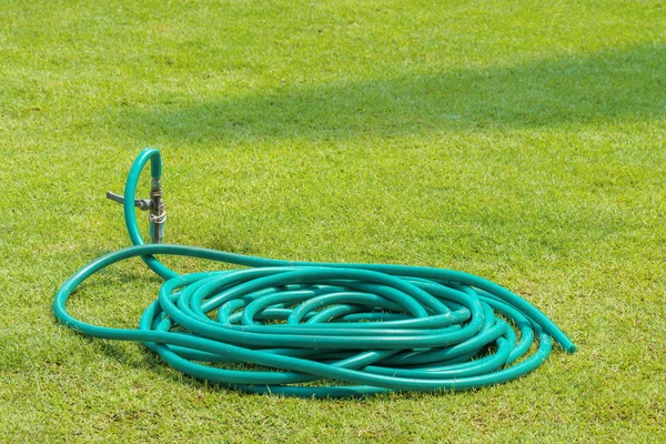 Rubber tube on grass in the garden — Stock Photo, Image