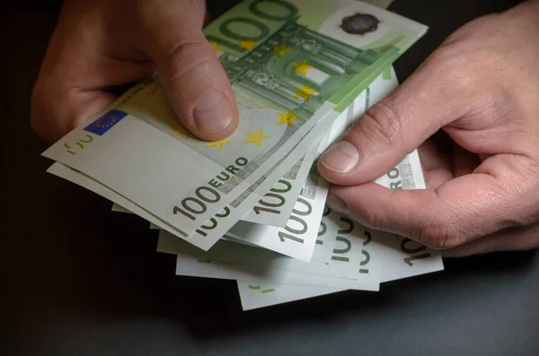 Several hundred-euro notes in the hands of a man. Euro close-up in a restrained manner. Jackpot, lottery winnings. The man counts the currency.