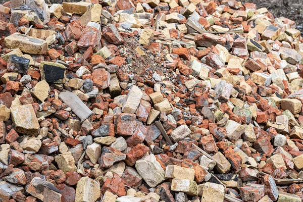 A pile of broken red bricks. A broken wall.