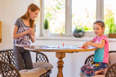 Kızlar masa oyunu oynar.