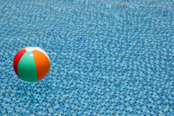 Bola de praia na piscina. Bola inflável colorida que flutua na piscina, conceito das férias do verão. — Fotografia de Stock