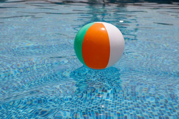 Bola de praia na piscina. Bola inflável colorida que flutua na piscina, conceito das férias do verão. — Fotografia de Stock