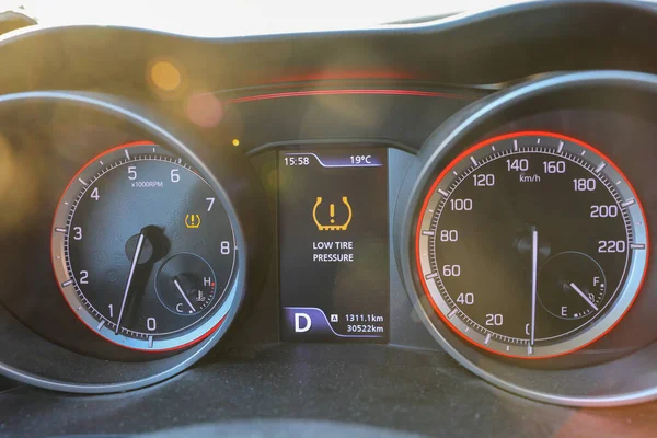 Low tire pressure error sign. Warning lights flash on the car dashboard. — Stock Photo, Image