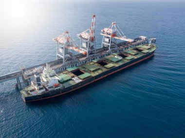 Toplu konteynır gemisi elektrik santralinin limanına kömür boşaltıyor..