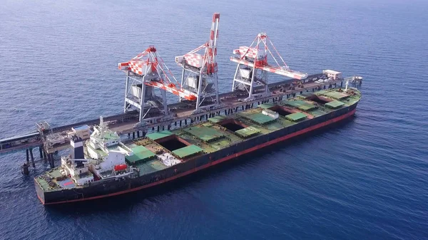 Toplu konteynır gemisi elektrik santralinin limanına kömür boşaltıyor..