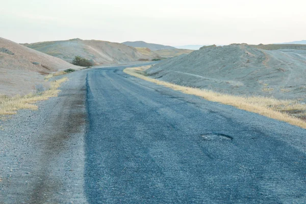 沙漠路上的裂缝混凝土。破碎的沥青路面. — 图库照片