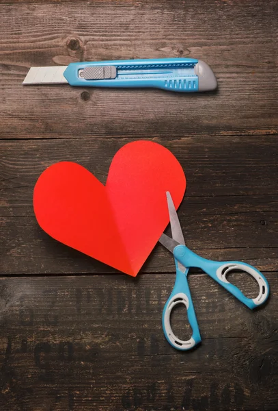 makas, bıçak ve koyu ahşap arka plan kağıda kalbinde. Sevgililer günü