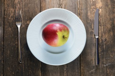 ahşap zemin üzerinde mavi bir kase kırmızı elmalar