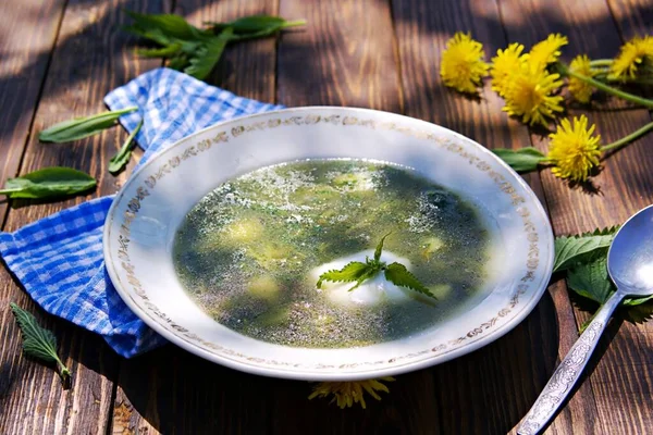 Hot nettle and sorrel soup with potatoes and sour cream in a vintage plate on a brown wooden background. Recipes with wild herbs. — Stock Image Hot Nettle Sorrel Soup Potatoes Sour Cream Vintage Plate Brown Royalty Free Stock Photos