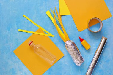 Adım adım çocuk el sanatları üretimi kozmonotik güne kadar, plastik şişelerden, folyolardan ve renkli kağıtlardan roketler. Üçüncü adım: Renkli kağıttan atölyeye ateş yapıştırmak. ÇOCUK .