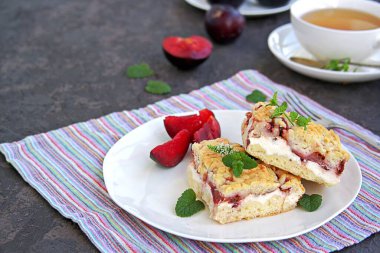 Beyaz bir tabakta kremalı ve erikli dilimlenmiş kurabiye pastası. Tatlı kekler. Erikleri hasat et.