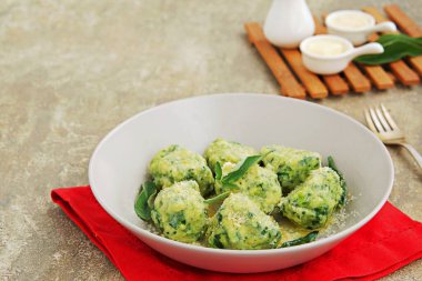 Ricotta ve ıspanaklı gnocchi ya da parmesan peynirli börek ve çimento kaplı gri bir tabakta adaçayı yağı. Ispanak tarifleri. İtalyan yemeği..