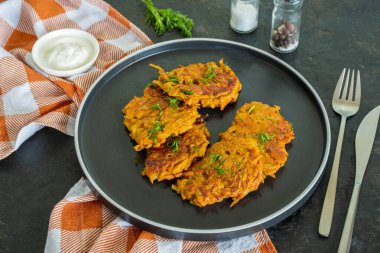 Siyah bir tabakta koyu beton bir zeminde tatlı patates ya da havuçlu börek. Vejetaryen tarifleri. Tatlı patates tarifleri.. 