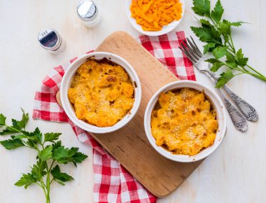 İki porsiyon peynirli makarna, peynir soslu makarna, açık beton arka planda beyaz seramik çerçeveler. Amerikan mutfağı. Geleneksel yemekler.