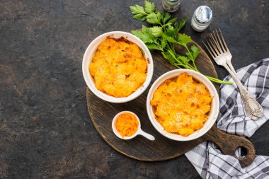 İki porsiyon peynirli makarna, peynir soslu makarna, beyaz seramik çerçeveli siyah beton arka plan. Amerikan mutfağı. Geleneksel yemekler.