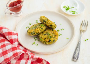 Hafif seramik tabakta hafif beton zeminde kızarmış hamburger ya da bulgur pirzolası, havuç ve ıspanak. Bulgur tarifleri. Tefecilik ve Venedik yemekleri