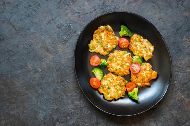 Kesilmiş tavuk göğsü ve brokoli şnitzeli siyah bir tabakta koyu beton arka planda. Brokoli tarifleri.