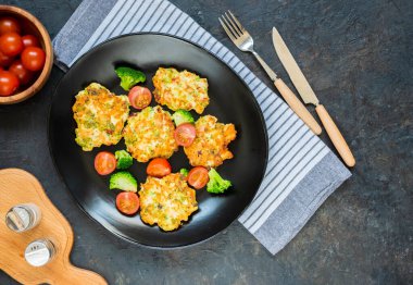 Kesilmiş tavuk göğsü ve brokoli şnitzeli siyah bir tabakta koyu beton arka planda. Brokoli tarifleri.