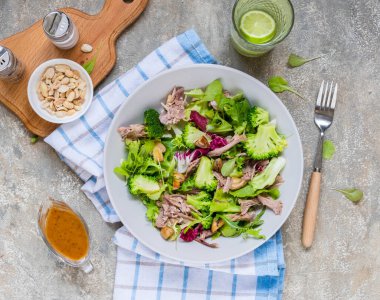 Kaynamış brokoli, ördek, kızarmış mantar ve açık beton arka planda gri bir tabakta fıstık soslu sağlıklı salata. Salata tarifleri. Sağlıklı yemek..